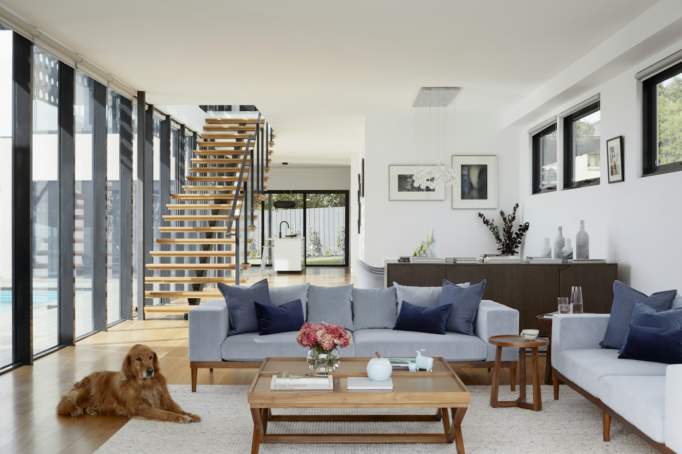 Sunlit living room with a mustard sofa, indoor plants and a round wooden table