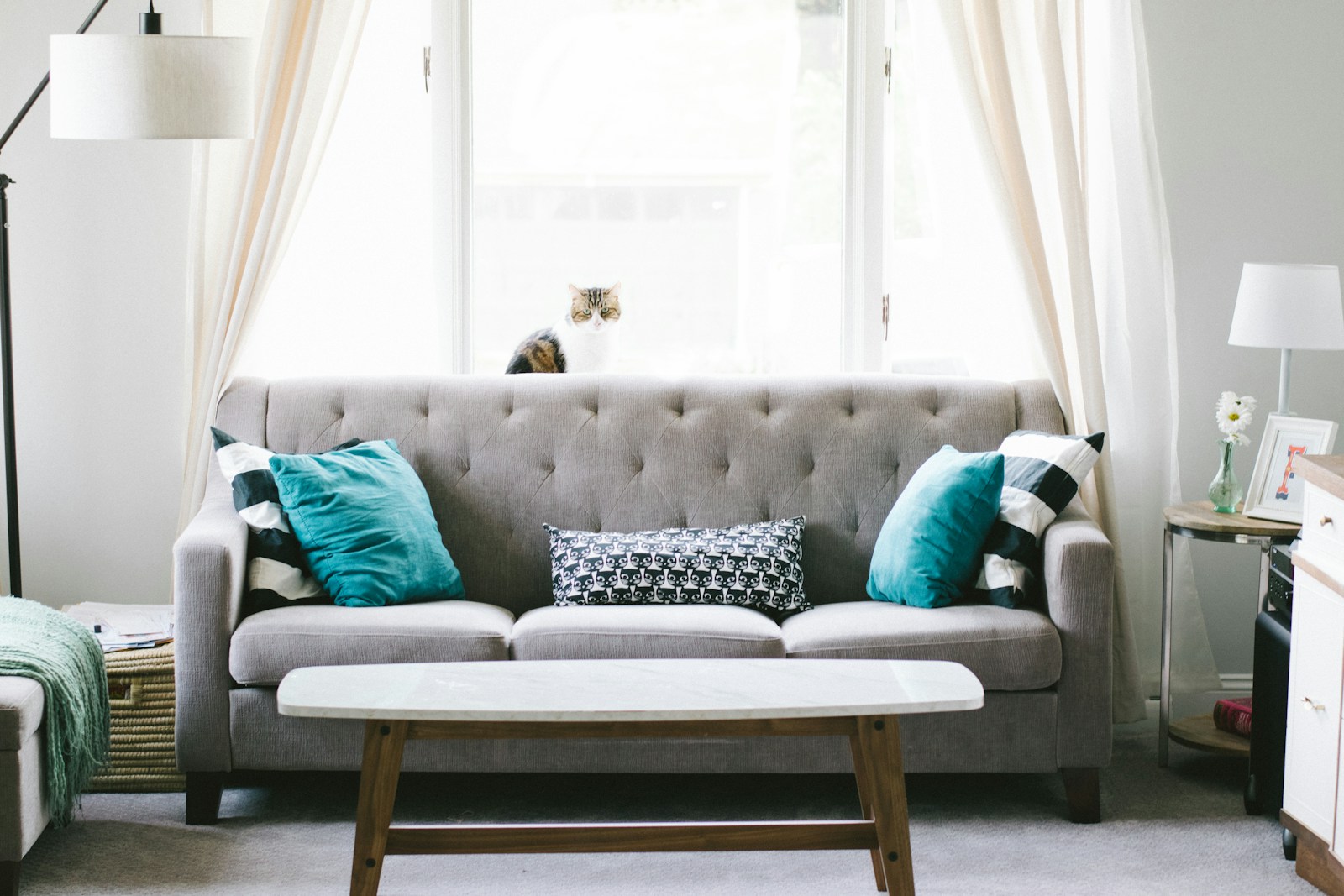 Sunlit living room with a mustard sofa, indoor plants and a round wooden table